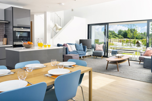 large modern kitchen diner with doors open onto garden