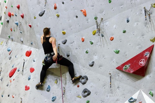 woman dressed in black on a climbing wall